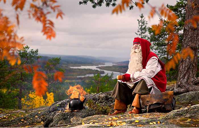Santa Claus enjoying coffee by open fire in Rovaniemi, Lapland, Finland