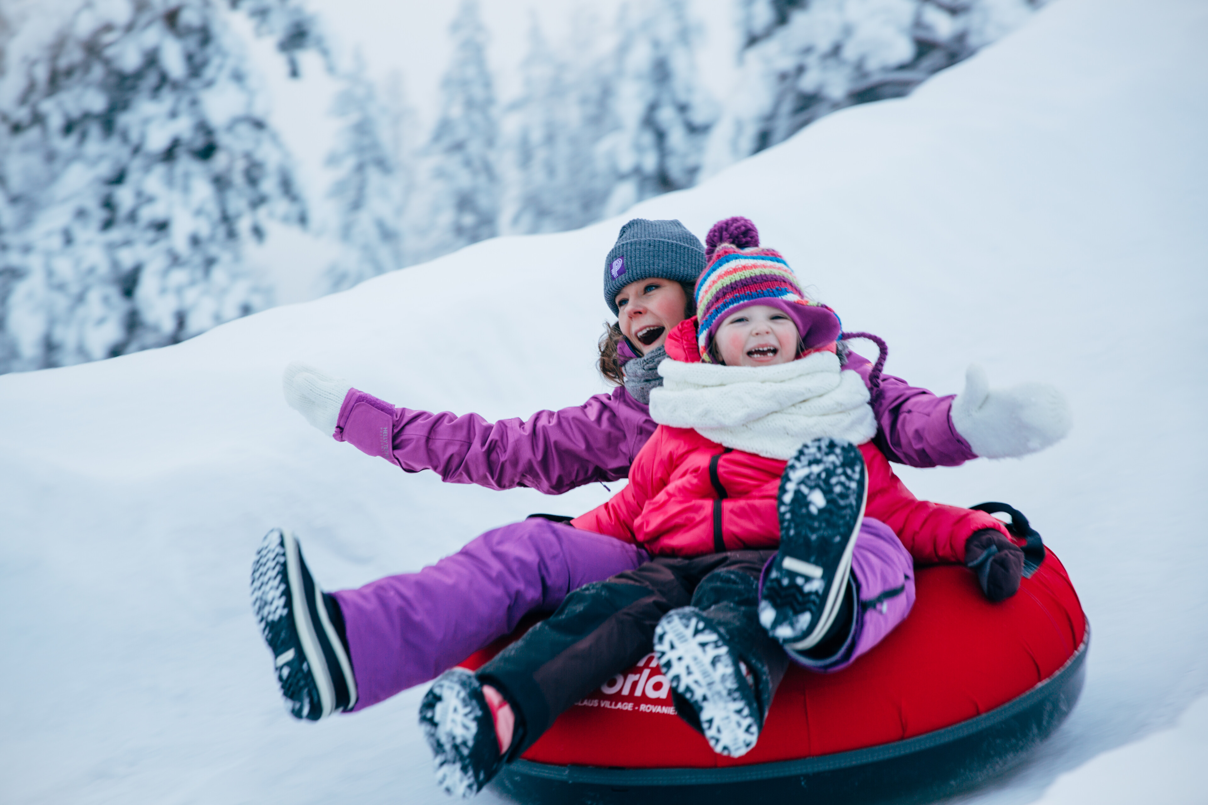 Perhe nauttimassa lumisesta talvipäivästä Snowmanworldissä, Napapiirillä, Rovaniemellä, Lapissa.