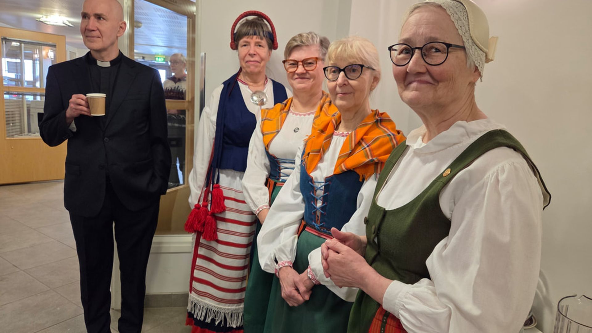 Kalevalaisia kansallispuvuissaan kirkkokahveilla.
