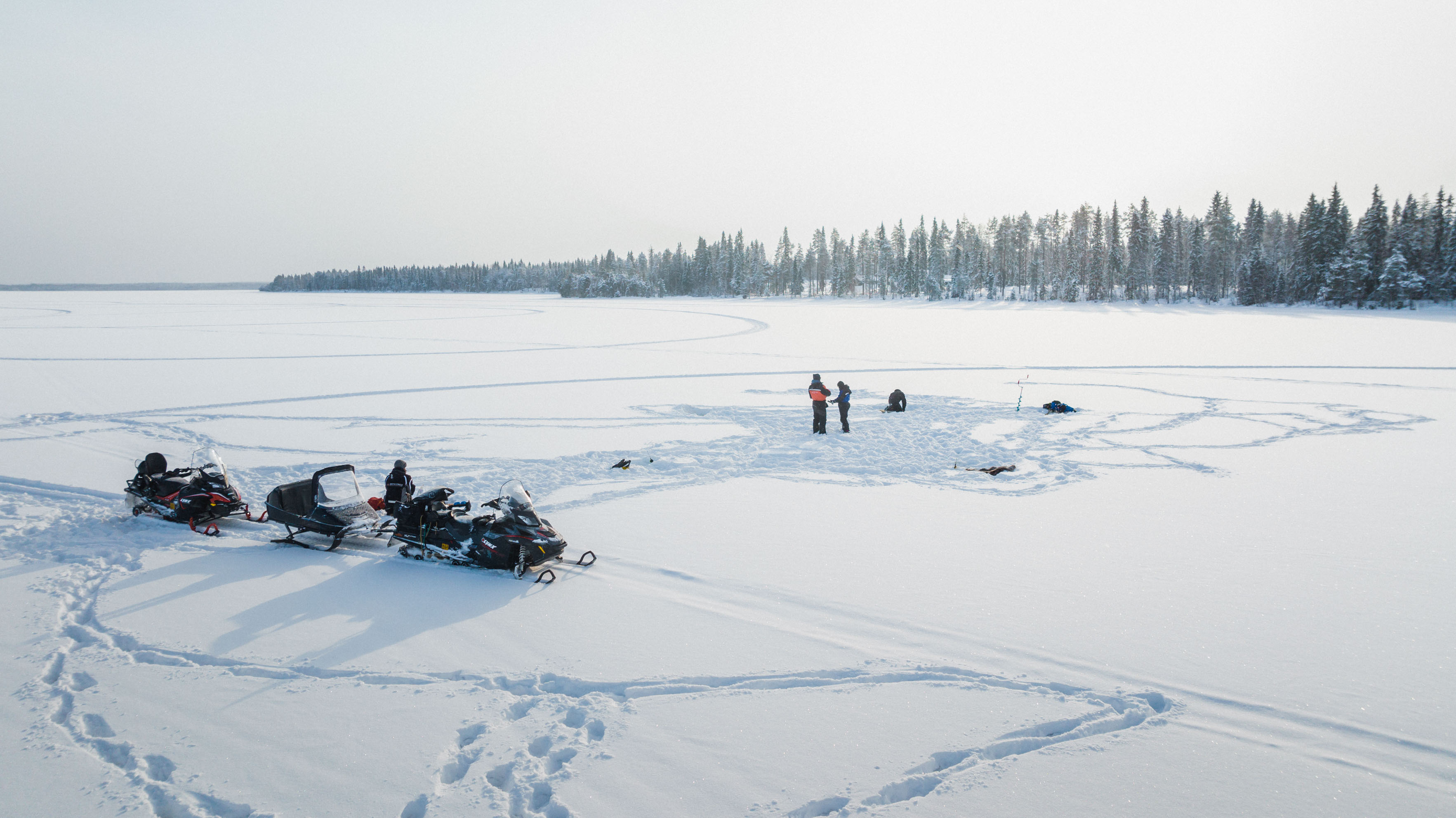 people snowmobiling on river ice in wintertime, Rovaniemi, Lapland, Finland