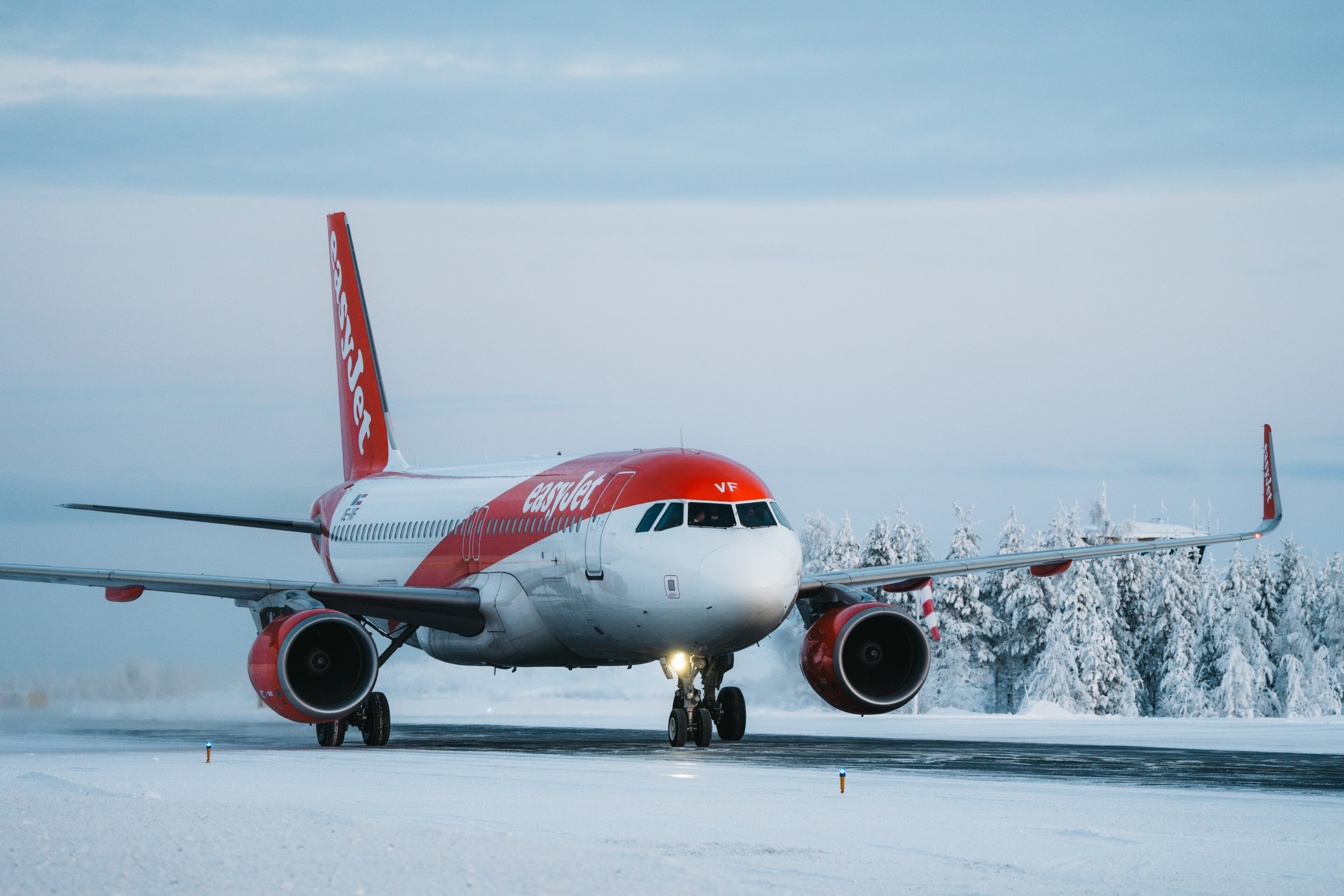 Easyjetin lentokone laskeutumassa Rovaniemen lentokentälle talvella kauniissa lumisessa maisemassa.