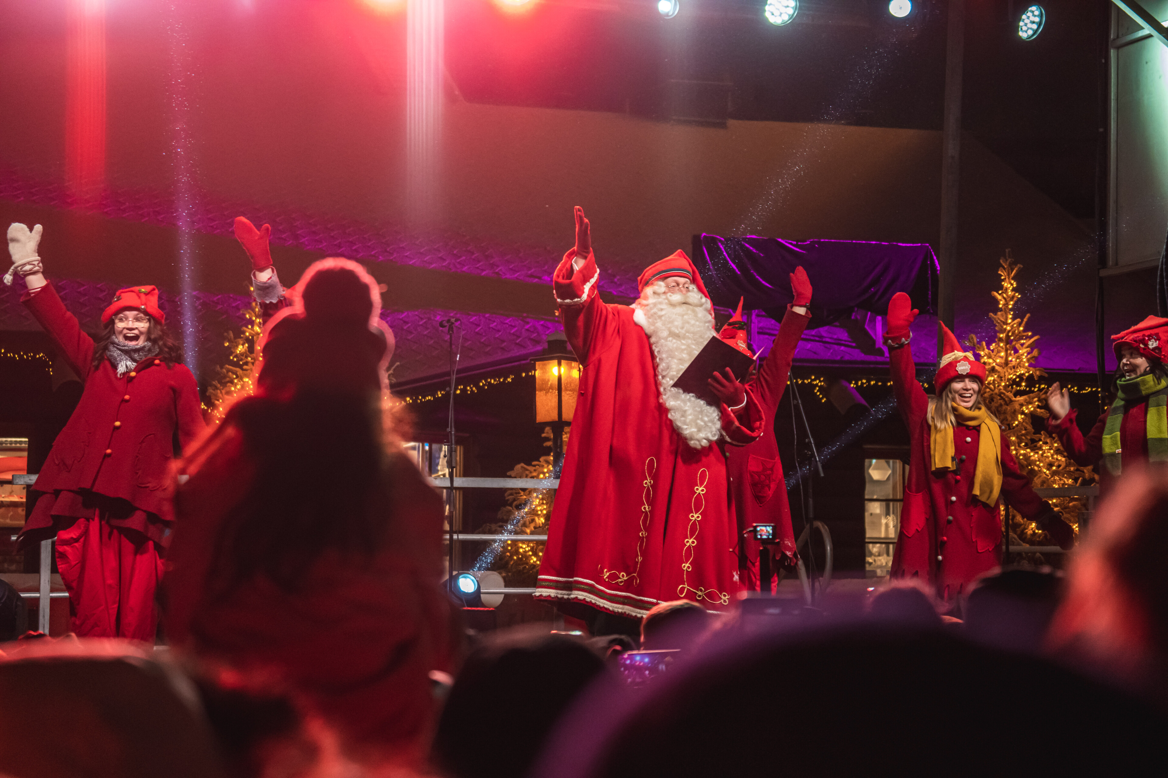 Joulupukki ja tontut lavalla Joulunajan tapahtumassa Joulupukin Pajakylässä, Rovaniemellä, Lapissa.