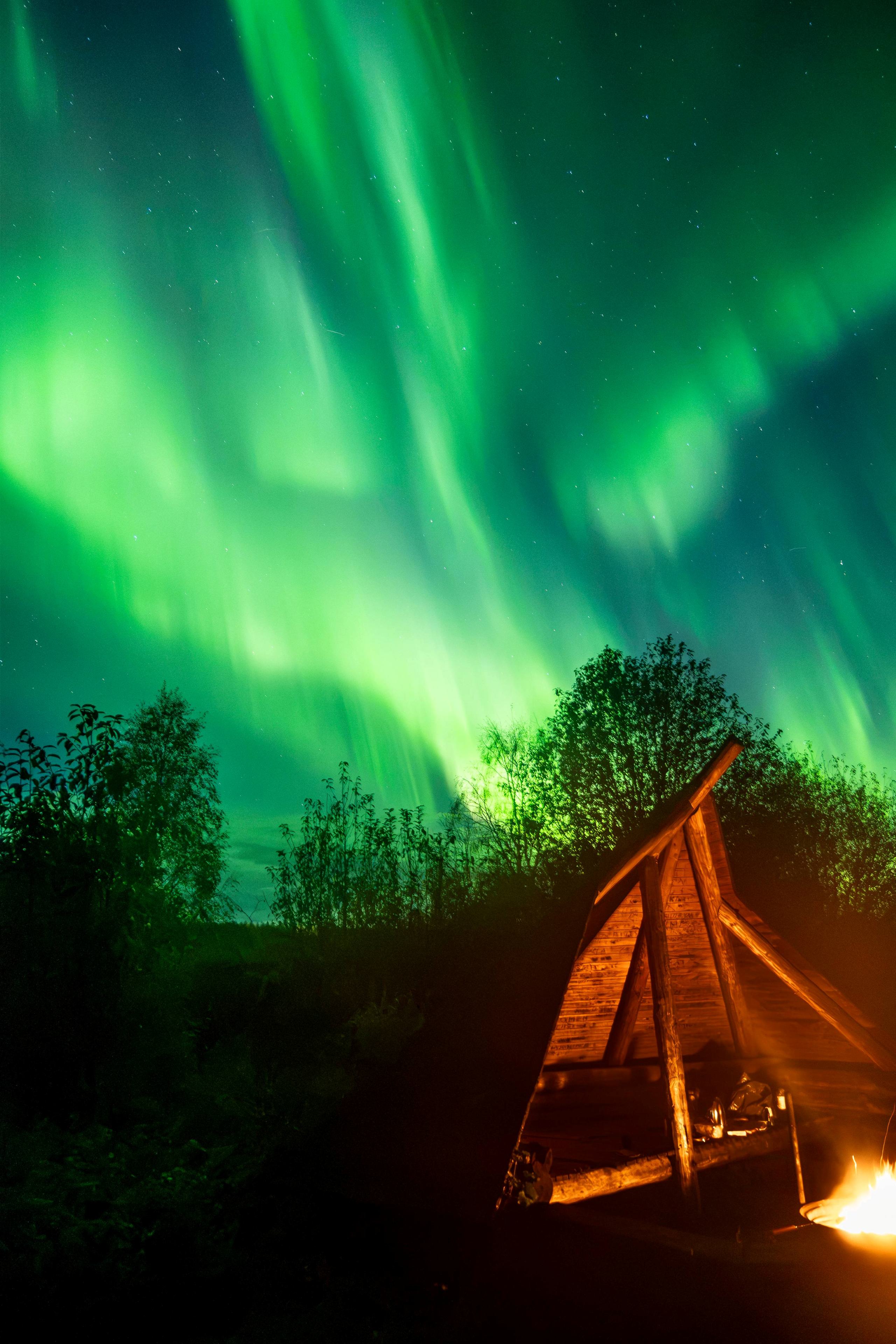 lean to shelter and northern lights in the sky.