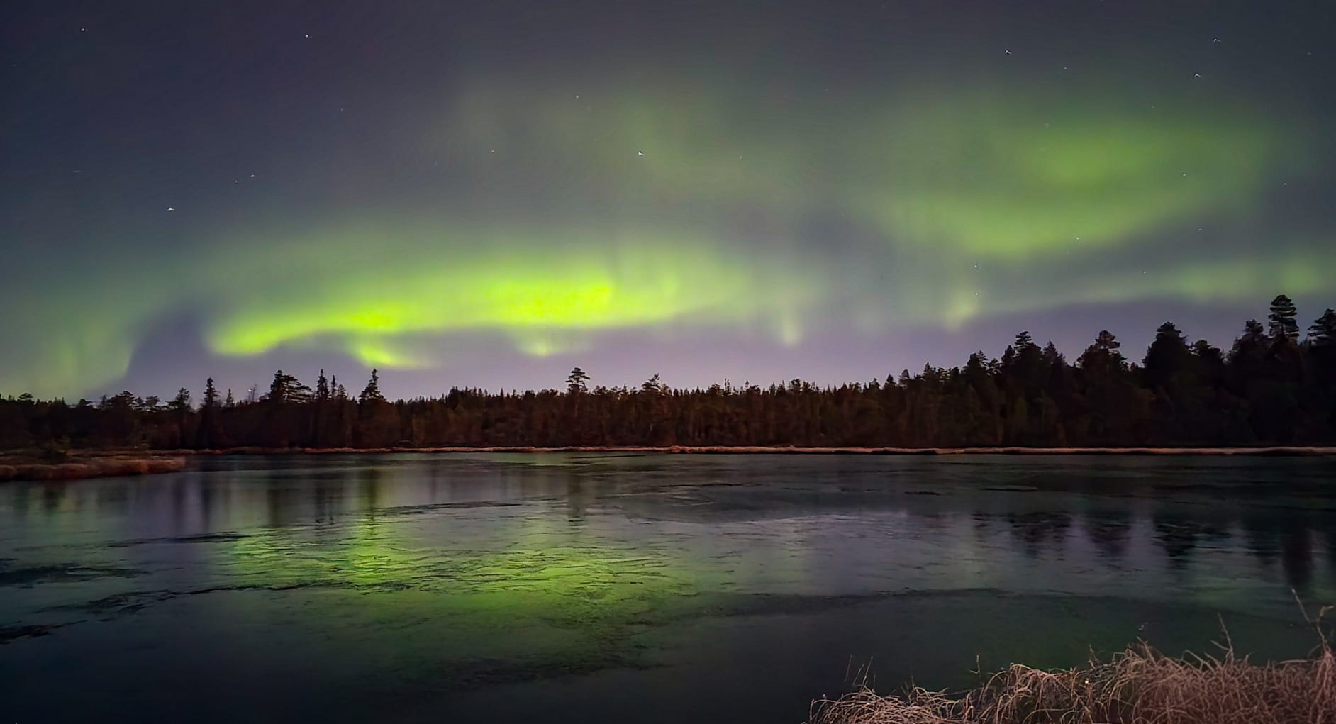 Aurora borealis over water in Rovaniemi, Lapland, Finland