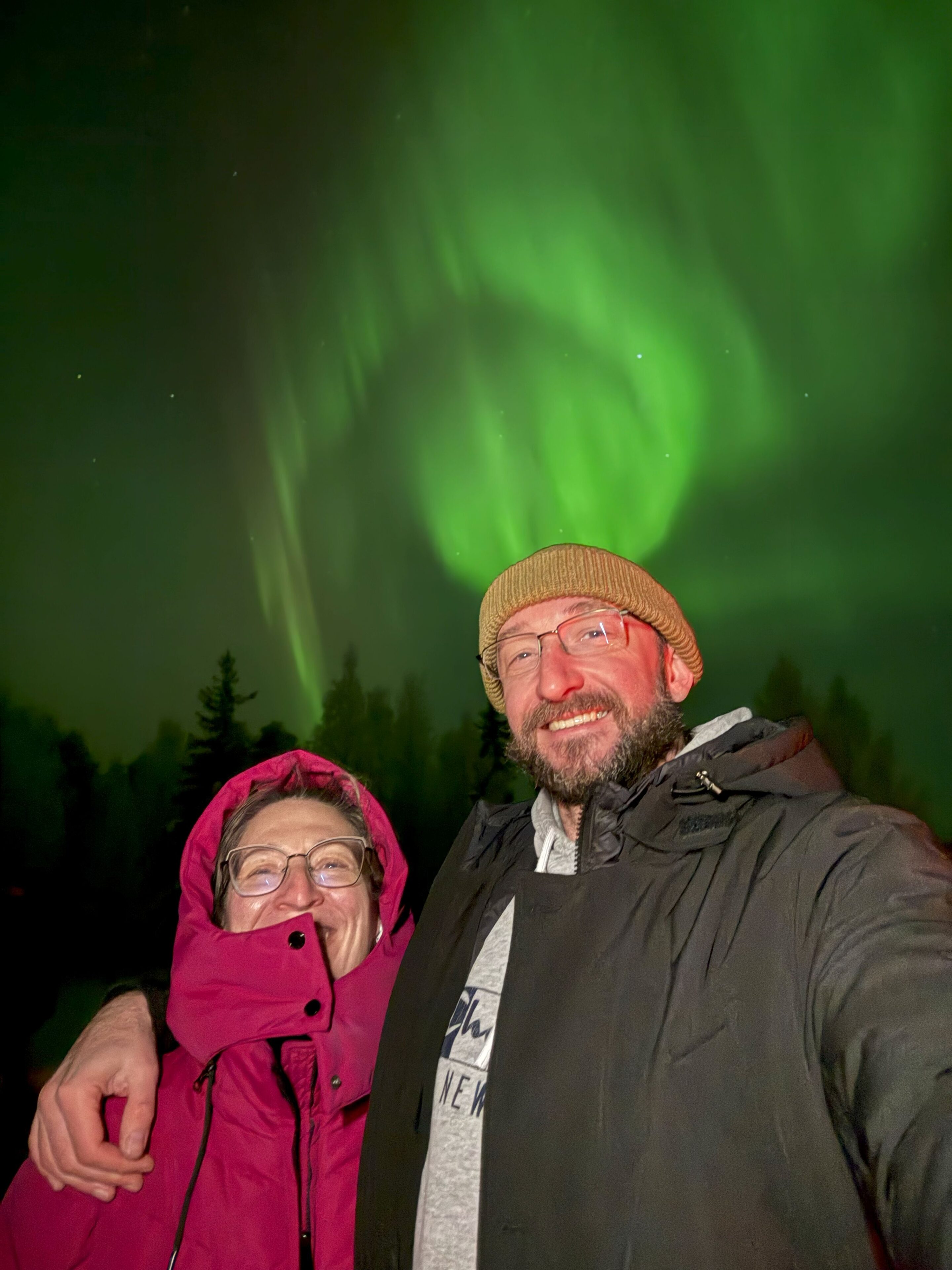 Couple enjoying northern lights together in Rovaniemi, Lapland, Finland.