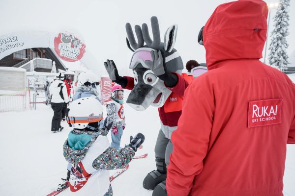 Ruka Ski Resort staff helping their mascot to downhill ski