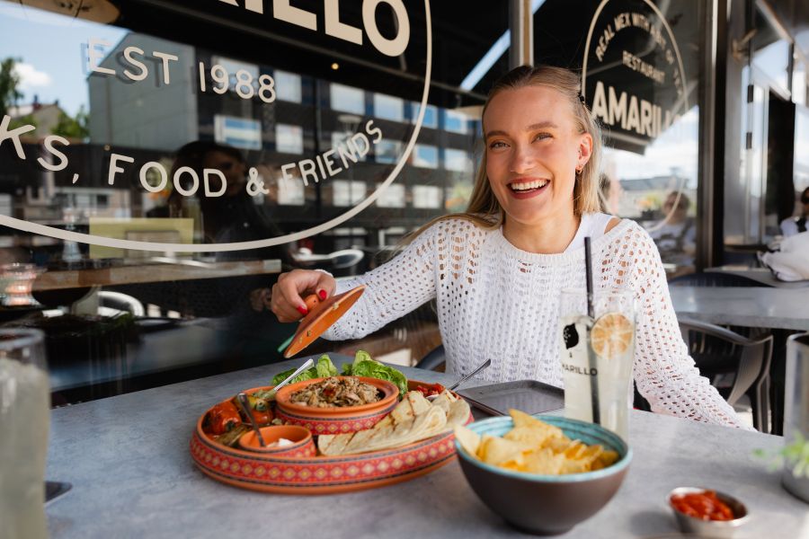 Smiling woman enjoying a meal.