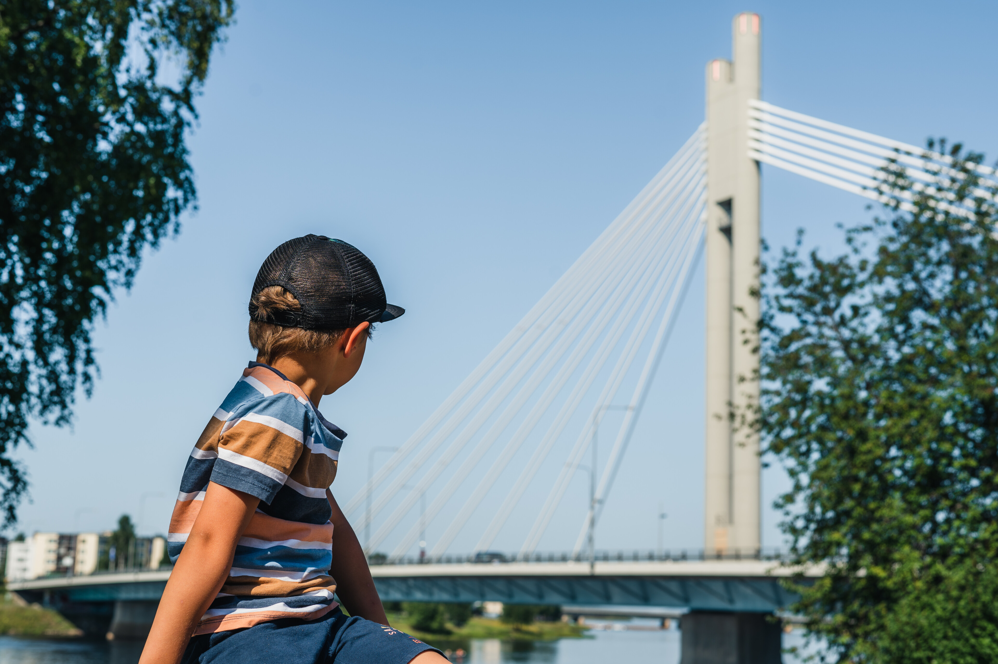 A boy in Valdemari restaurant watching over to Kemijoki during summer in Rovaniemi, Lapland, Finland.