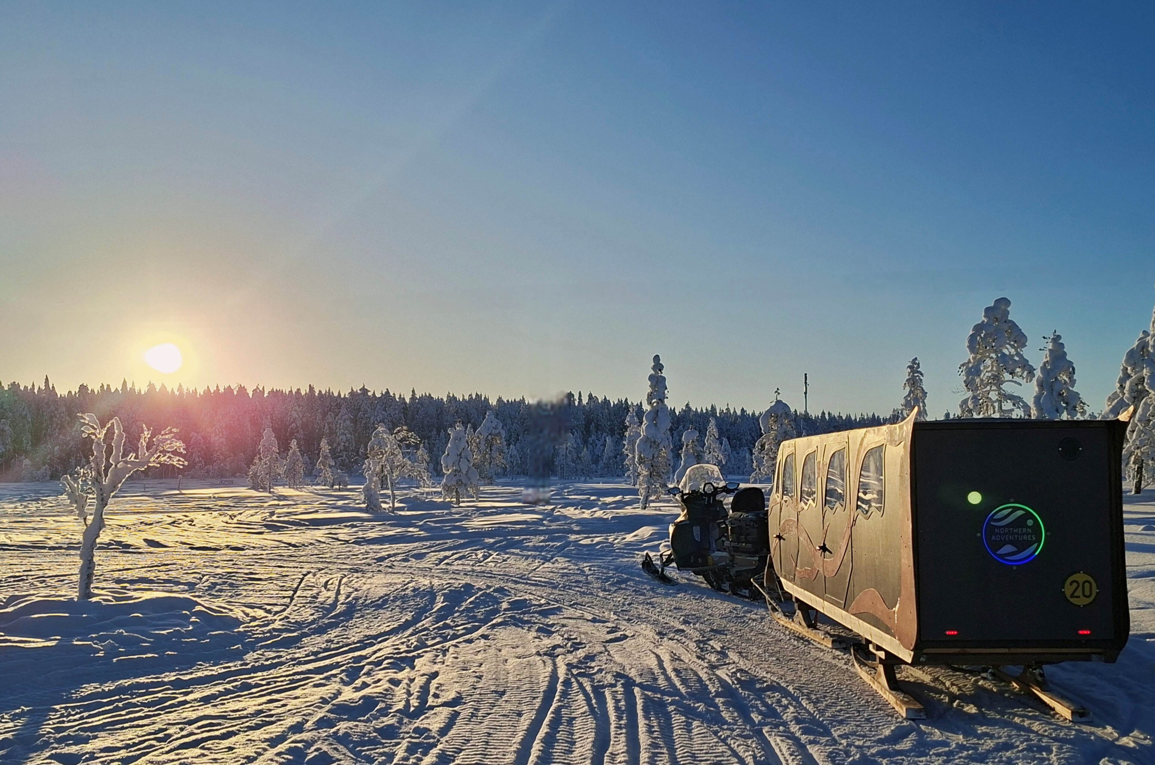 Snowmobile pulling sledge in winter landscape with Northern Adventures, Rovaniemi, Lapland, Finland.
