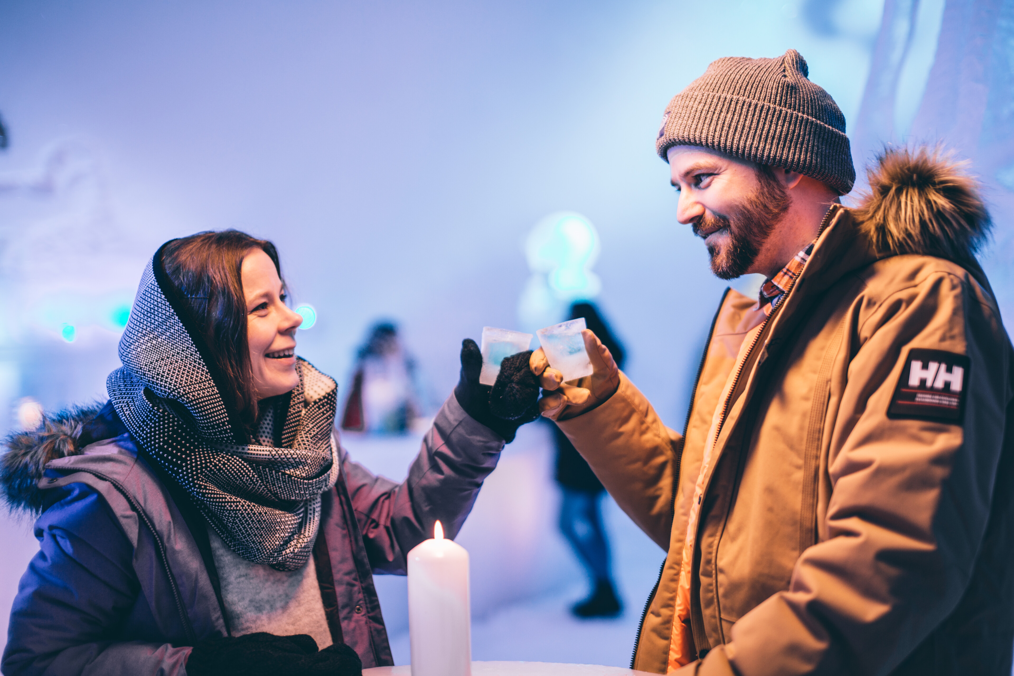 A couple enjoying ice drinks from ice glasses in snow restaurant in Rovaniemi, Lapland, Finland.