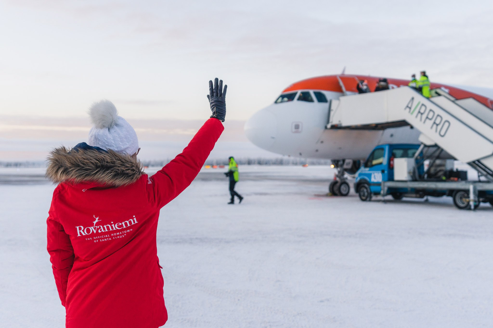 Sanna Kärkkäinen waving at easyjet inaugural during winter in Rovaniemi Airport, Lapland, Finland.