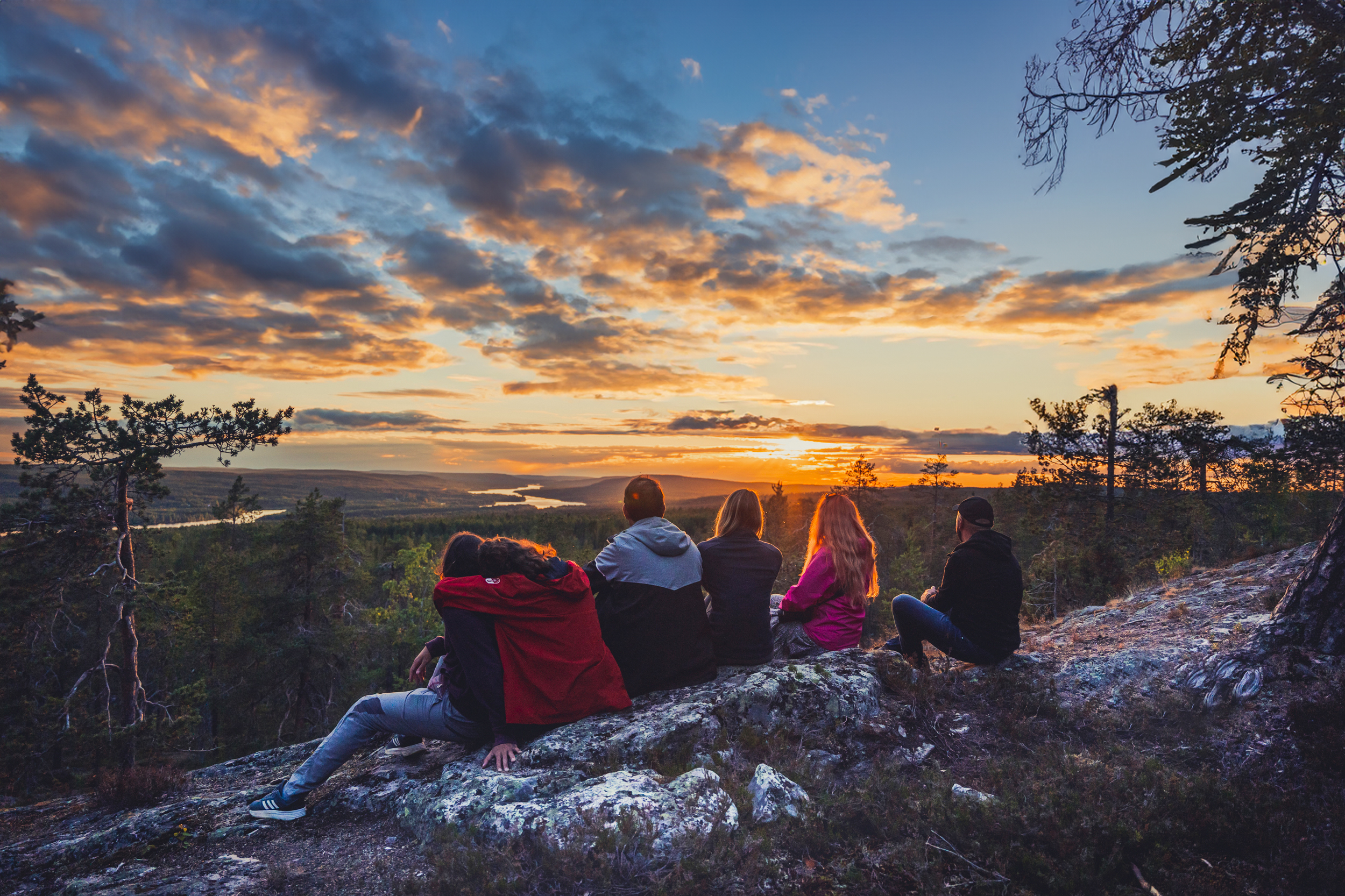 Ihmiset nauttimassa Kuninkaanlaavun maisemista kesällä yöttömässä yössä Rovaniemellä, Lapissa.